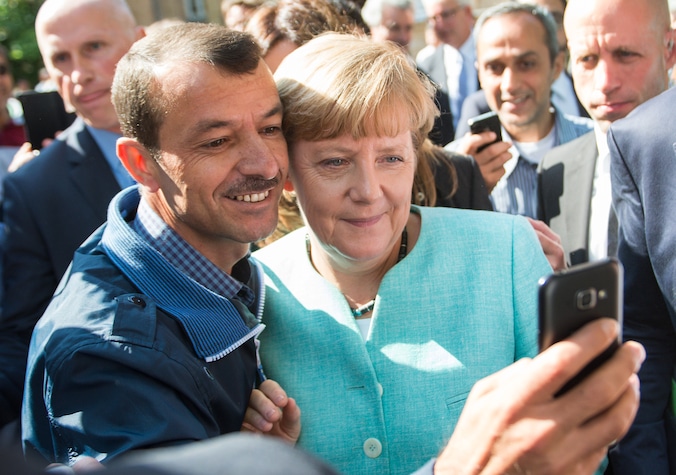 Bondskanselier Merkel poseert met vluchtelingen bij een onthaalcentrum voor asielzoekers in Berlijn, in september vorig jaar.