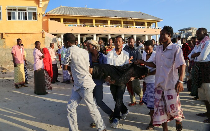 Mensen dragen een slachtoffer weg na de aanslag in Mogadishu.
