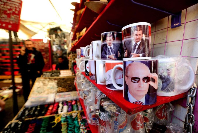Een winkeltje in Damascus verkoopt mokken met een foto van Poetin of Assad.