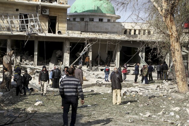 Inwoners meten de schade op na een bombardement op Aleppo door het Syrische leger.