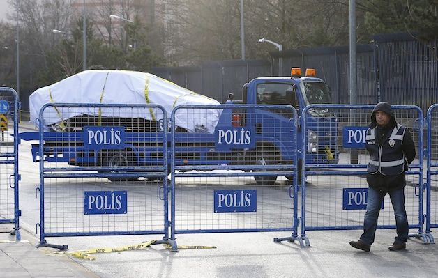 De politie voert een door de aanslag beschadigd voertuig weg.
