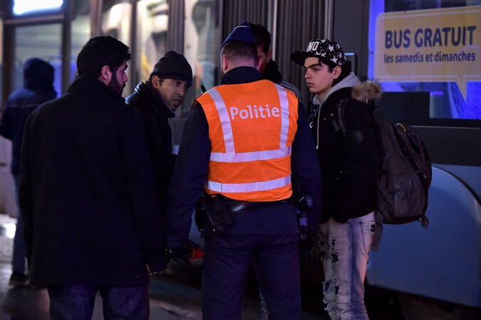 De politie controleert aan de Belgisch-Franse grens in Adinkerke (De Panne) vluchtelingen op een Franse lijnbus. Archieffoto 23 februari 2016.