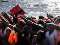 Migranten op weg naar Italië krijgen reddingsvesten aangereikt vanop een reddingsboot van Artsen Zonder Grenzen en SOS Mediterranee.