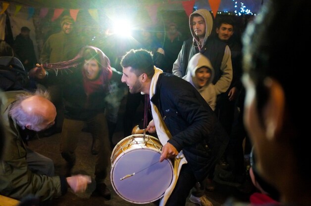Ambiance in één van de geïmproviseerde feesttenten. Een bejaarde Franse bezoeker (links) laat zich meeslepen op het Arabische ritme.