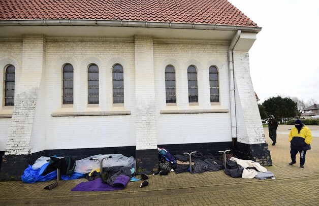 Iraanse christelijke migranten slapen tegen de gevel van de kerk in Zeebrugge.