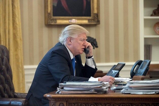 Donald Trump aan telefoon met Angela Merkel, gisteren.