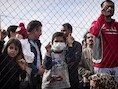 Vluchtelingen achter een hek in een kamp in Athene. Griekenland en Italië krijgen daar aangekomen vluchtelingen en migranten amper naar andere lidstaten versluisd.
