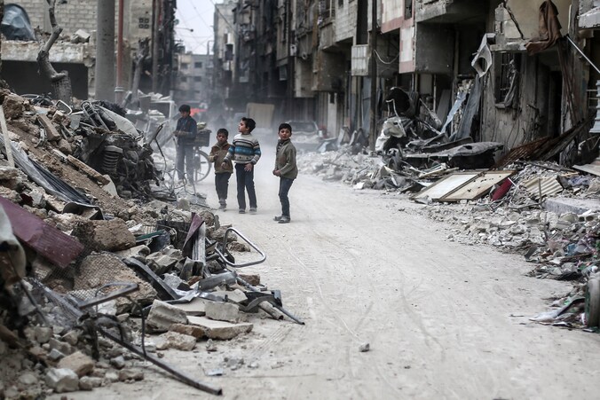Kinderen te midden van het puin in Douma, Syrië. Het puin is afkomstig van gebouwen die op 25 januari getroffen werden door luchtaanvallen.
