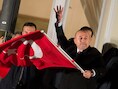 De Turkse minister van Buitenlandse Zaken Mevluet Cavusoglu, zwaaite met een Turkse vlag terwijl hij zijn aanhangers in Hamburg toewuift.