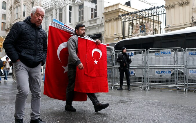 Het Nederlandse consulaat in Istanbul is volledig afgezet en staat onder politiebewaking. Intussen probeert een verkoper zijn Turkse vlaggen aan de man te brengen.