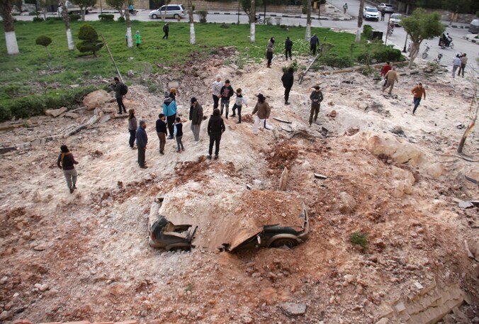 Syriërs nabij Idlib na een luchtaanval op 10 april.
