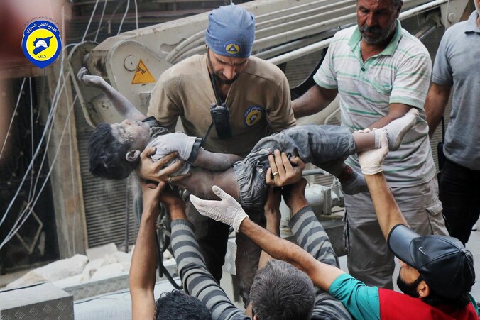 Leden van de Witte Helmen dragen het lichaam van een kind weg in het onder rebellenbewind staande deel van Aleppo.