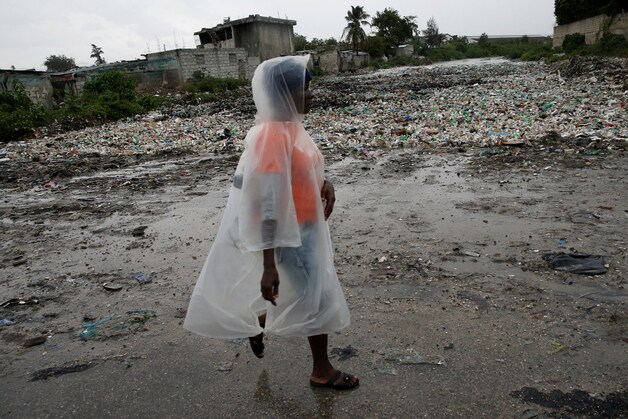 Een vrouw loopt langs een rivier in Port-au-Prince.