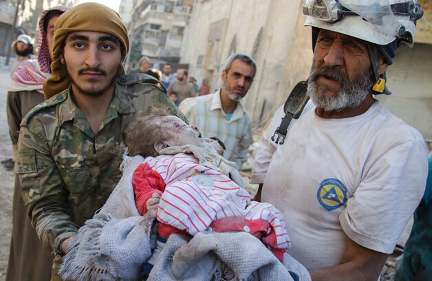Leden van de Syrian Civil Defence, gekend als de 'Witte Helmen', dragen het lichaam van een meisje uit het puin van een gebouw dat vernield werd tijdens luchtaanvallen.