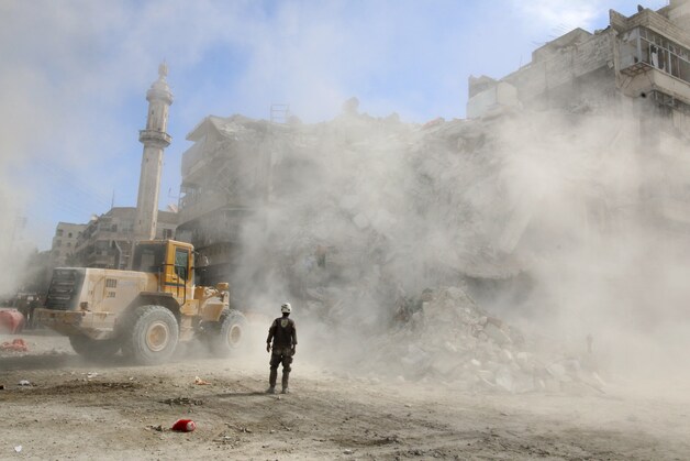 Een laadschop ruimt het puin na een luchtaanval die gisteren op Aleppo werd uitgevoerd.