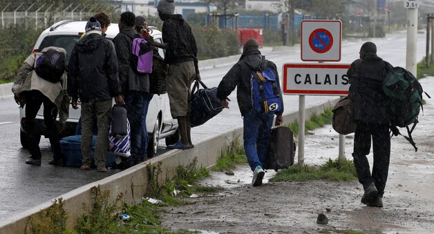Migranten vertrekken uit de 'Jungle van Calais'.