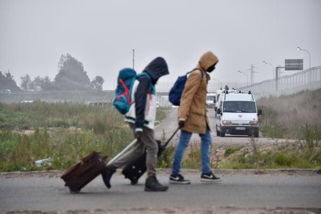Migranten verlaten de Jungle met hun bagage vanochtend.