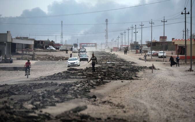 Mensen op een weg tussen Qayyarah en Mosul tijdens de operatie van Irakese krachten om de stad te heroveren op IS.