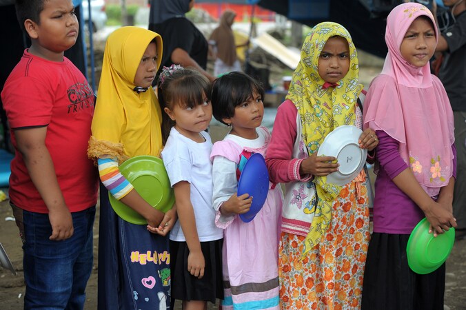 Kinderen staan in de rij voor een voedselbedeling in Pidie Jaya, in de provincie Atjeh.