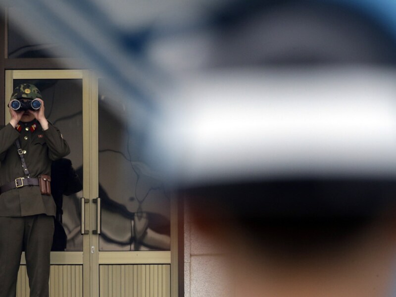 Een Noord-Koreaanse soldaat (links) kijkt op afstand naar een Zuid-Koreaanse soldaat, aan de grens bij Panmunjom, gisteren.