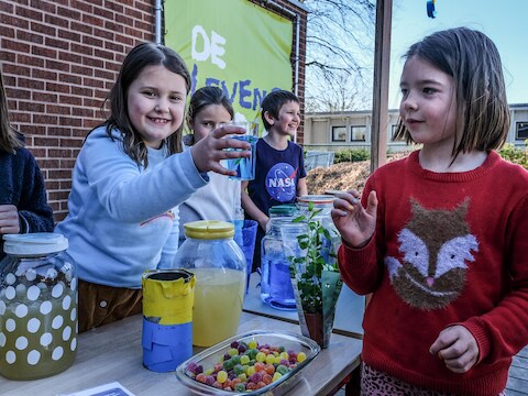Ella Vanmaele staat tweede van links op deze foto, met een glas blauwe limonade in haar hand
