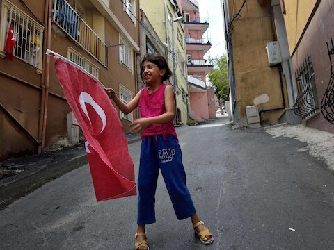 Een meisje speelt met de Turkse vlag in de buurt waar president Recep Tayyip Erdogan geboren is.