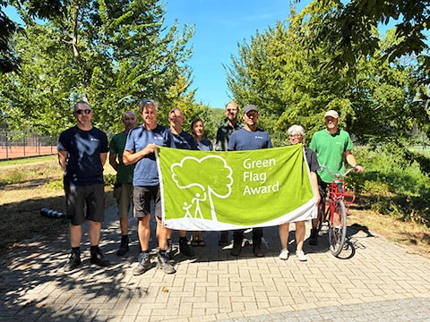 Medewerkers van het Vrijbroekpark met de Green Flag Award-vlag