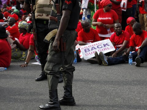 Gewapende Nigeriaanse agenten bij demonstranten die eisen dat de regering de zoektocht naar de meisjes opdrijft.