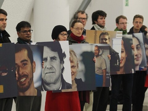 Greenpeace-activisten houden foto's vast van de gearresteerde 'Arctic 30'.