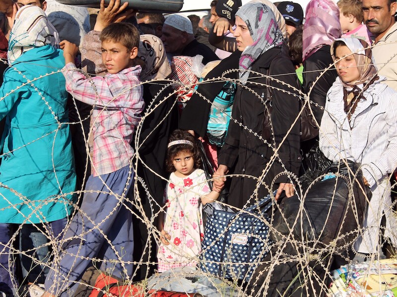 Syrische vluchtelingen staan in de rij bij de Turkse grens.