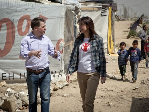 De directeur van Save the Children loopt met ambassadeur Samantha Cameron door een vluchtelingenkamp in Libanon.