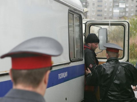Een activist van Greenpeace stap uit een politiebus bij de rechtbank in Moermansk.