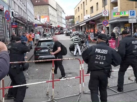 Op beelden is te zien hoe de man agenten lijkt te bedreigen met in zijn handen een kleine bijl of pikhouweel en een molotovcocktail.