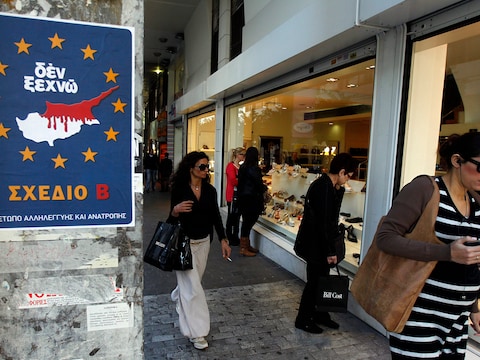 Een winkelstraat in Athene. Op het bord, met een kaart van Cyprus en de sterren als symbool van de Europese Unie, staan de woorden "Ik vergeet niet".