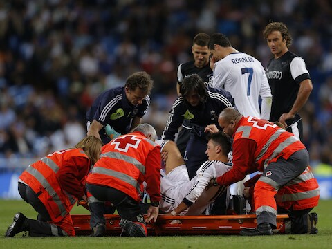 Mesut Özil verlaat het veld op de brancard.