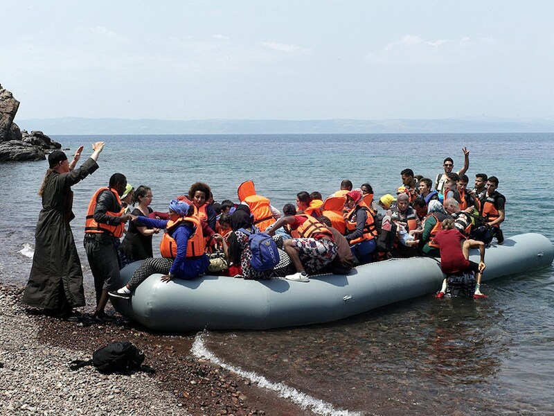 Een Grieks-orthodoxe priester verwelkomt vluchtelingen op het Griekse eiland Lesbos.