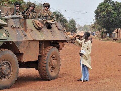 Een inwoner van Bangui benadert een Franse militaire patrouille.