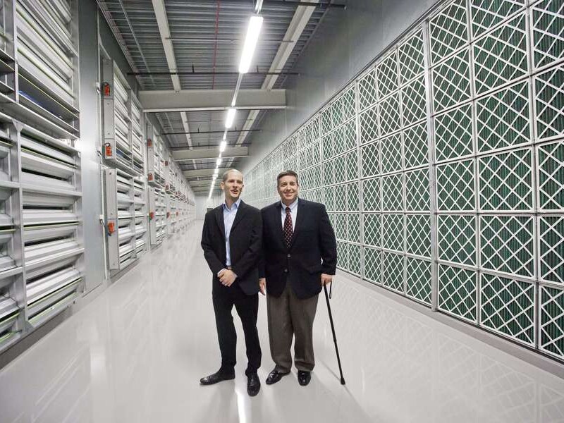 Tom Furlong, Vice President, Facebook Site Operations en Joel Kjellgren, Data Centre Manager, staan in de serverhal van het nieuwe datacenter.