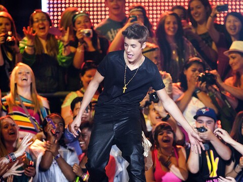 Justin Bieber wordt op handen gedragen door zijn fans.