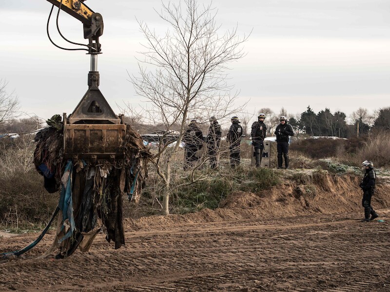 Kranen en bulldozers worden begeleid door oproertroepen om tenten en shelters te ruimen.