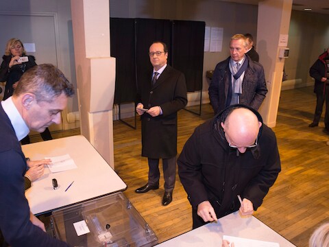 President François Hollande schuift aan om zijn stem uit te brengen.