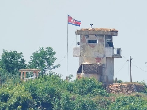 Een soldaat staat op wacht bij een Noord-Koreaanse militaire post, gezien vanuit Paju in Zuid-Korea.