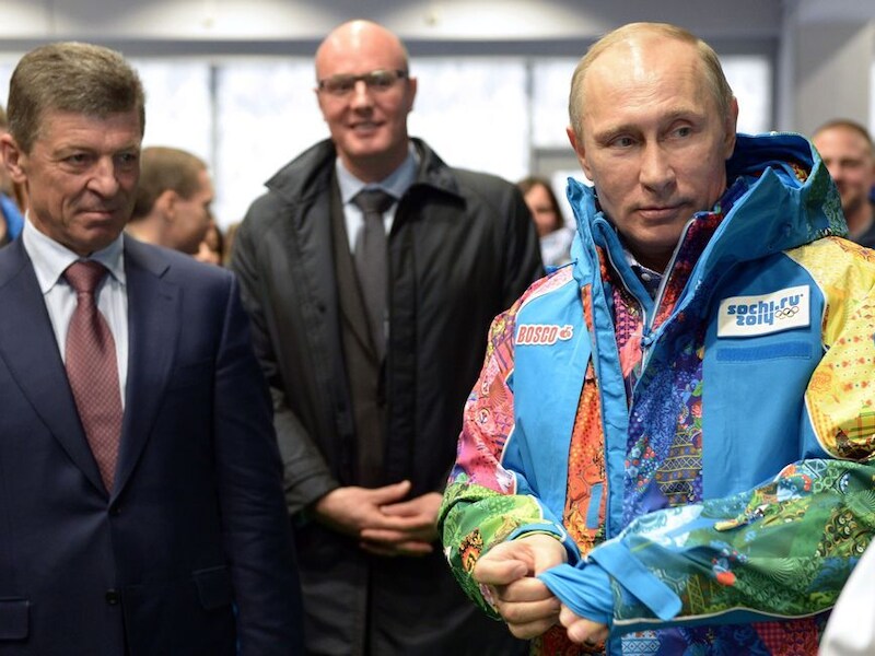 President Poetin past een vrijwilligersjas van de Olympische Spelen in Sotchii