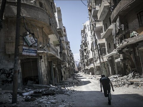Een aanhanger van de Syrische oppositie probeert in het zwaar gehavende Aleppo buiten schot te blijven.