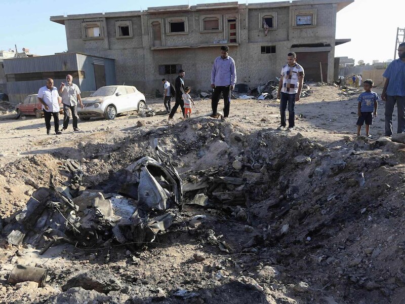 Burgers nabij de plaats waar dinsdag een militair vliegtuig crashte door gevechten in Benghazi.