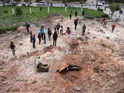 Syriërs nabij Idlib na een luchtaanval op 10 april.