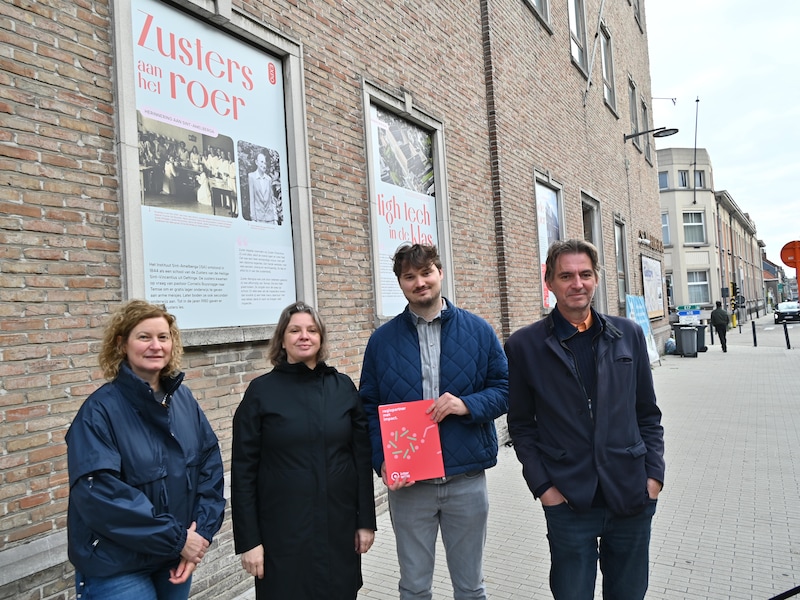 Sophie Vermeire van de cultuurdienst Temse, Sandy Van Handenhove van Erfgoedcel Waasland, Michaël Witters van Interwaas en schepen Bert Bauwelinck bij de buitenexpo aan de gevel van de vroegere school