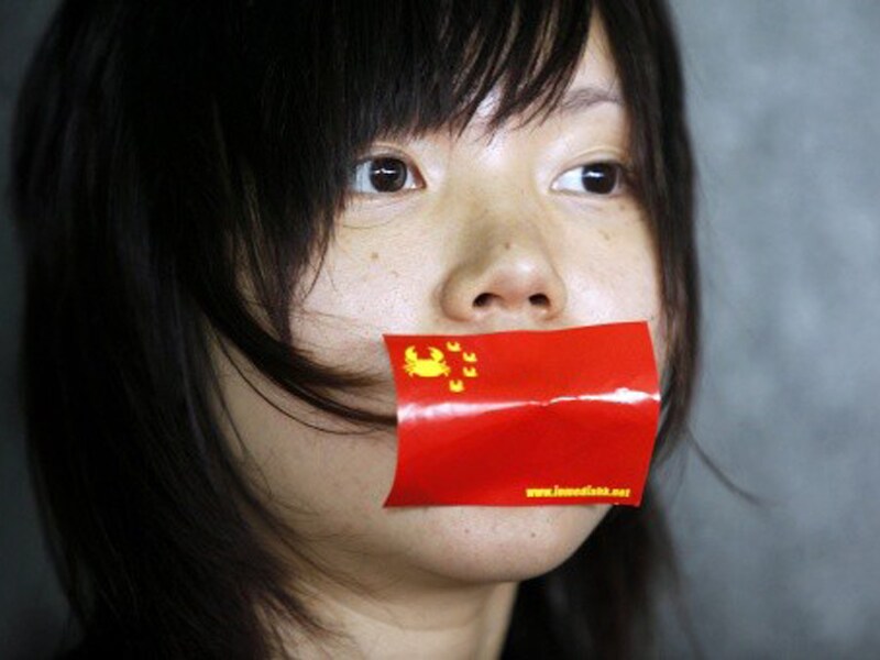 Een demonstrante in Hongkong klaagt de Chinese aanpak van de vrije meningsuiting aan.