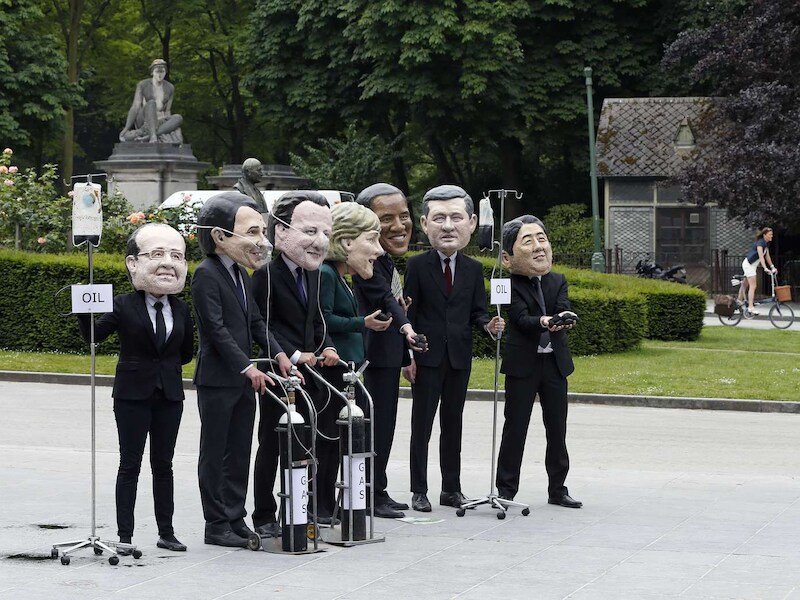 Oxfam-activisten demonstreren in Brussel met de maskers van de G7-leden op