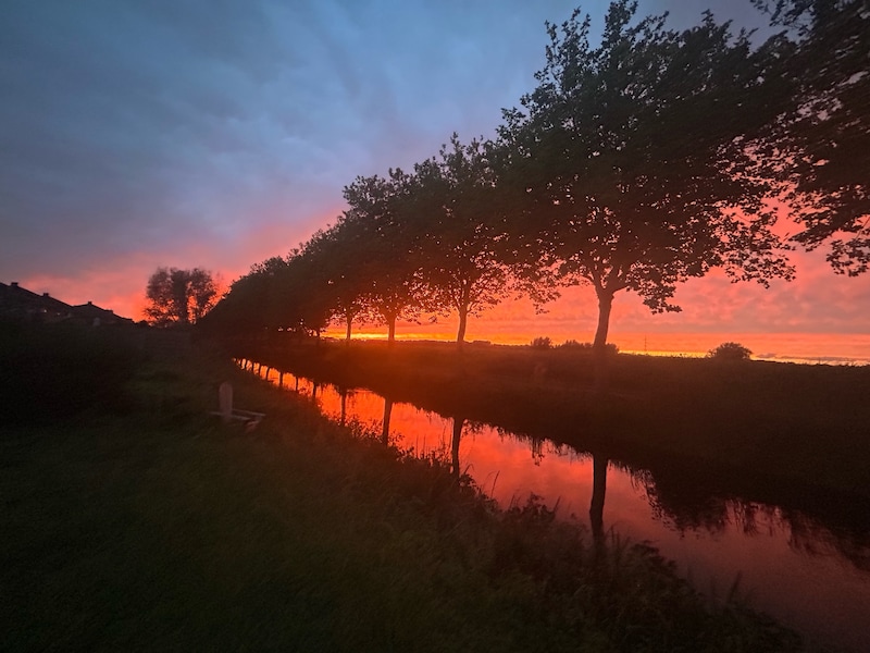 Hemel boven Kluizen kleurt felrood en oranje bij zonsondergang
